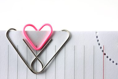 Heart shape paper clip on the adge of leaf clipart