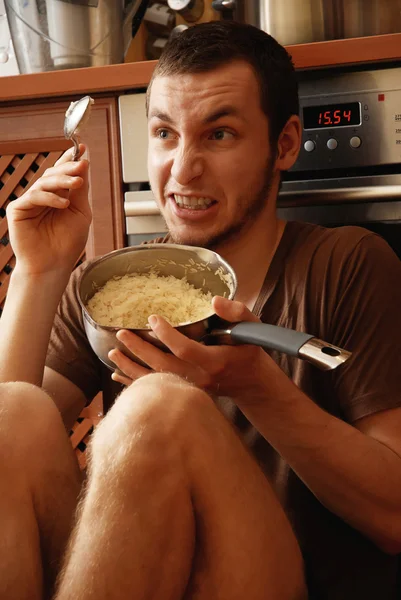 台所で稲のポットを持つ男 — ストック写真