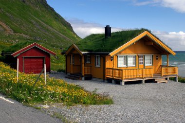 Yellow wooden house with grass roof clipart