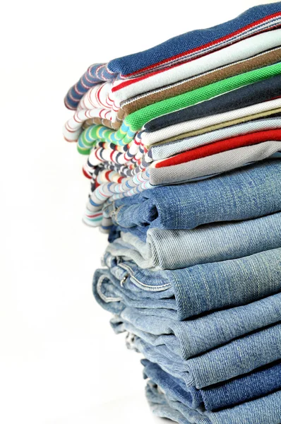 Stack of jeans and colorful t-shirts — Stock Photo, Image