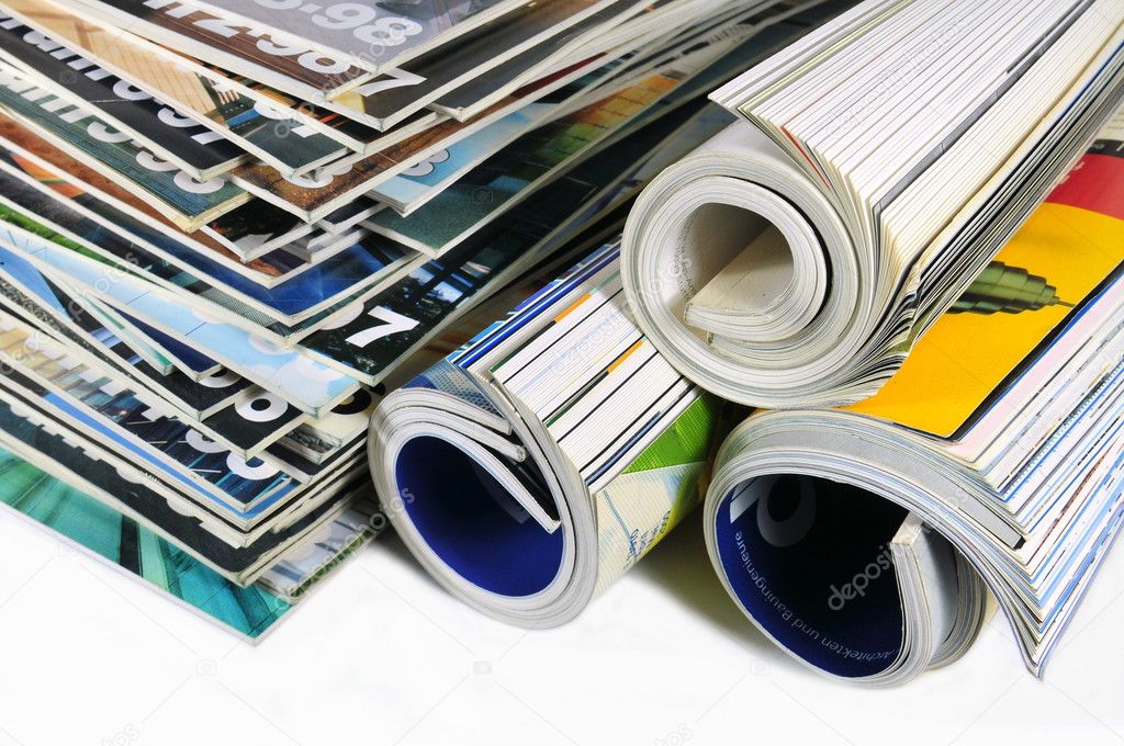 Stacked and rolled up magazines over white background