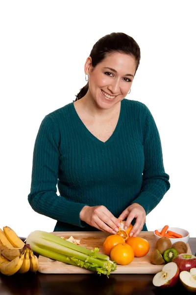 Donna in cucina peeling arancione — Foto Stock