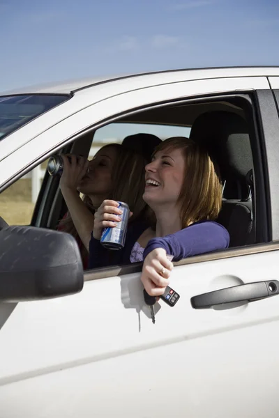 Dos mujeres en el coche bebiendo alcohol — Foto de Stock