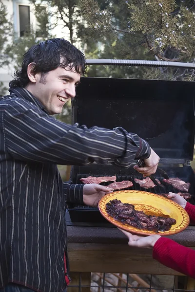 Mężczyzna grillowania mięsa na grillu — Zdjęcie stockowe