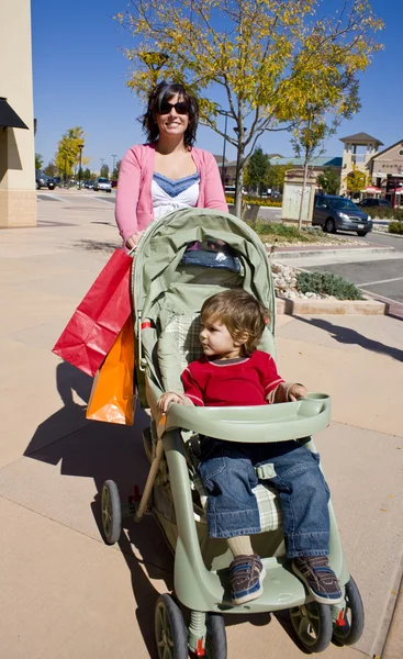 Bir bebek arabası itme ve çanta holding alışveriş kadın