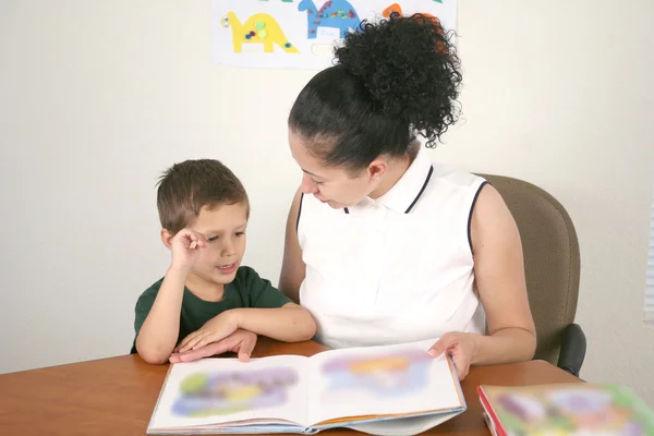 Preschool student and teacher reading a book
