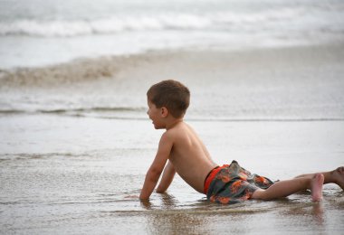 genç çocuk plaj ve dalgalar üzerinde oynama