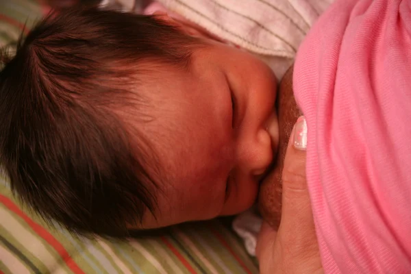 Young newborn baby breast feeding at nipple — Stock Photo, Image