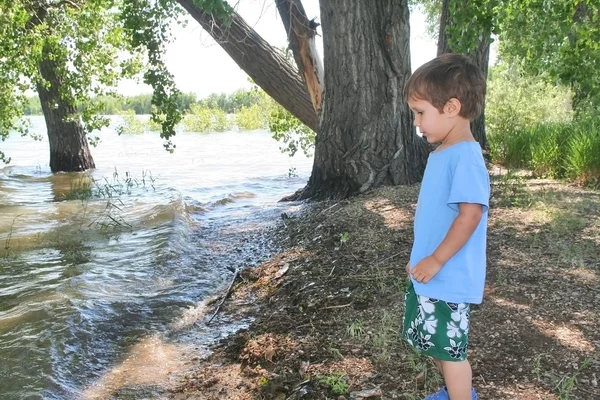 Jovem de pé na margem de um lago — Fotografia de Stock