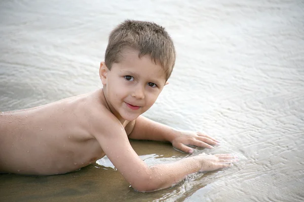 Young boy playing on the beach and waves — Stock Photo, Image