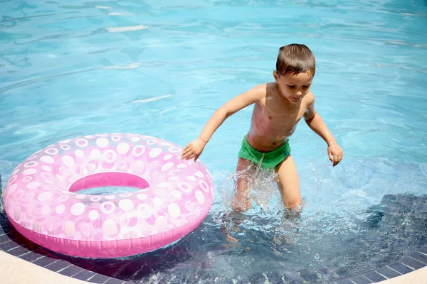 Genç çocuk bir havuzda oynarken — Stok fotoğraf