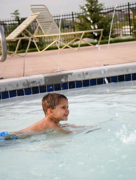 Mladý chlapec hraje v bazénu — Stock fotografie