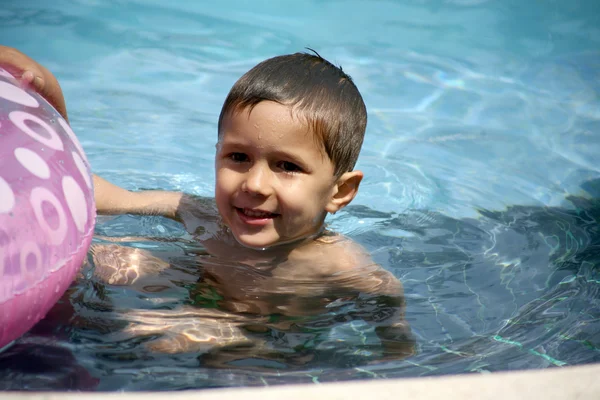 Genç çocuk bir havuzda oynarken — Stok fotoğraf