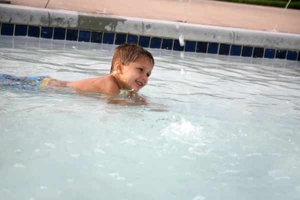 スイミング プールで遊んでいる若い少年 — ストック写真
