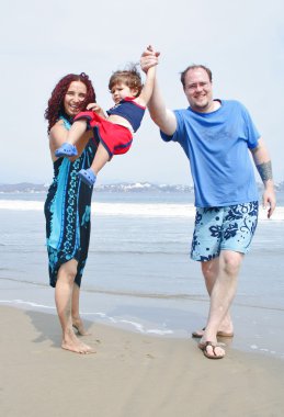 genç bir aile, birlikte sahilde çalış
