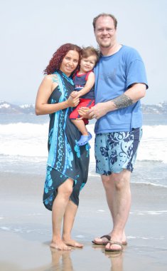 genç bir aile, birlikte sahilde çalış