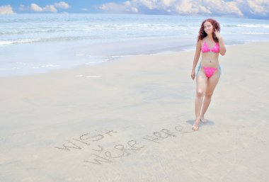 Beautiful young woman enjoying a day at the beach clipart