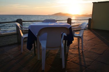 tropikal bir restoranda gün batımında tablo