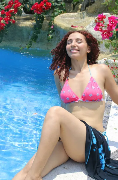 Vacker ung kvinna avkopplande av poolen — Stockfoto