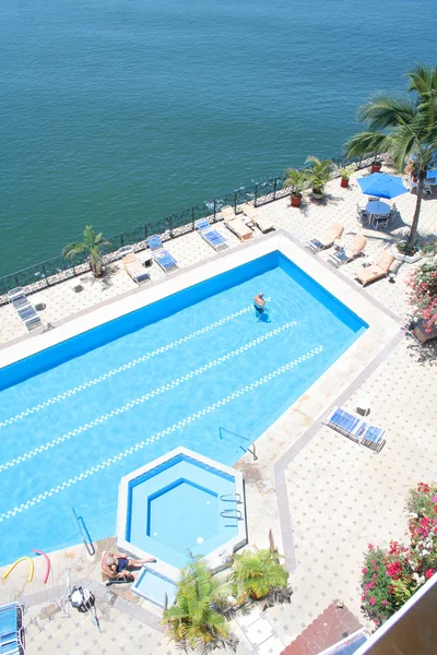 Tropisch zwembad naast het blauwe oceaanwater — Stockfoto