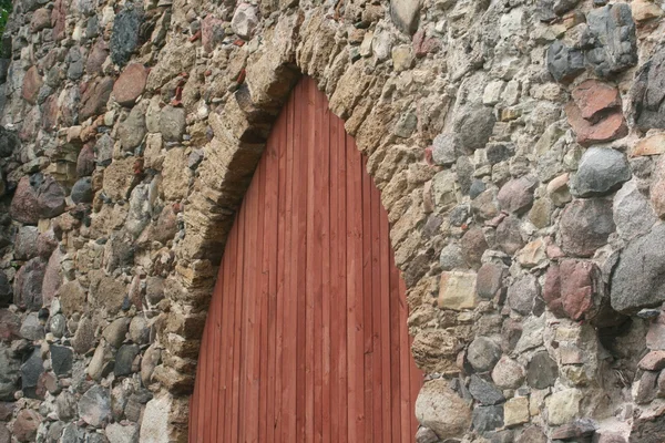 Wooden door in ancient stone wall — Stock Photo, Image