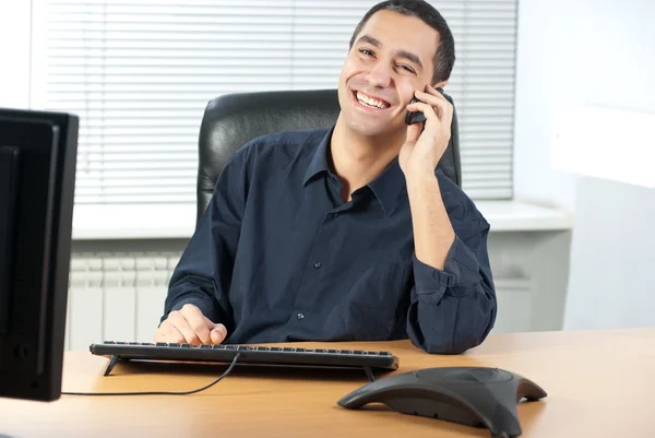 Бизнесмен разговаривает по телефону в офисе — стоковое фото