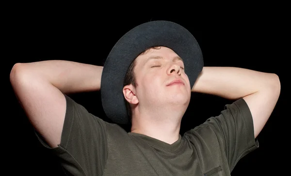 Mladý muž v klobouku odpočinek — Stock fotografie