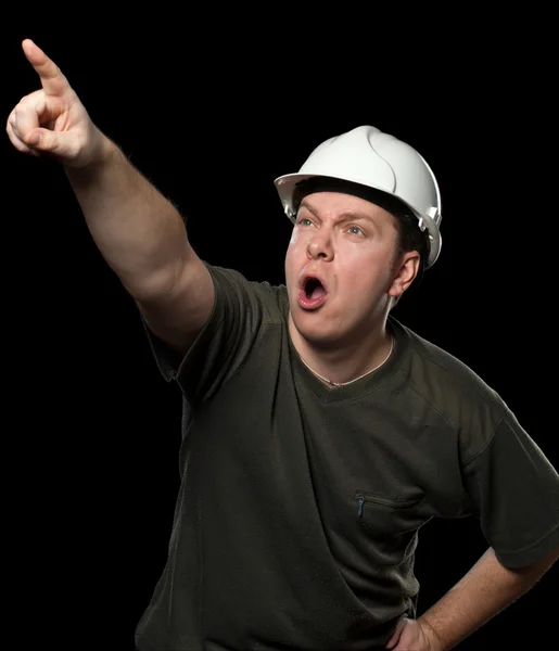 Werknemer in witte helm wijst naar iets — Stockfoto
