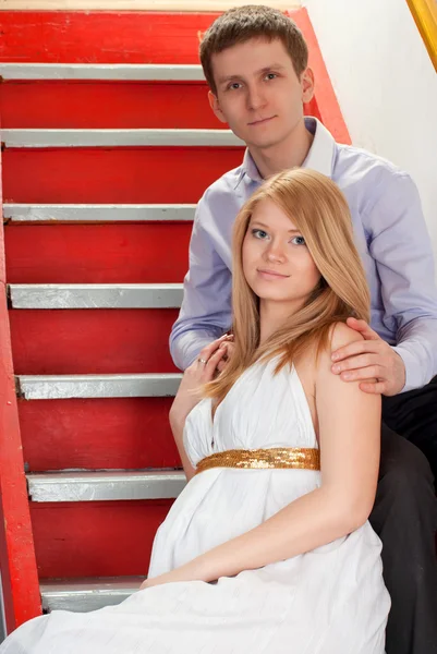 Casal grávida em uma escada — Fotografia de Stock