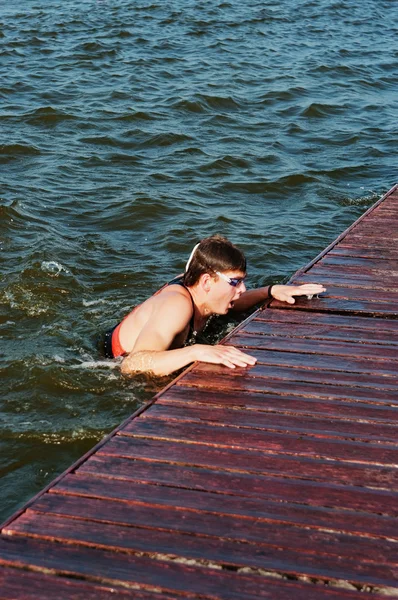De jonge sporter springt uit water — Stockfoto