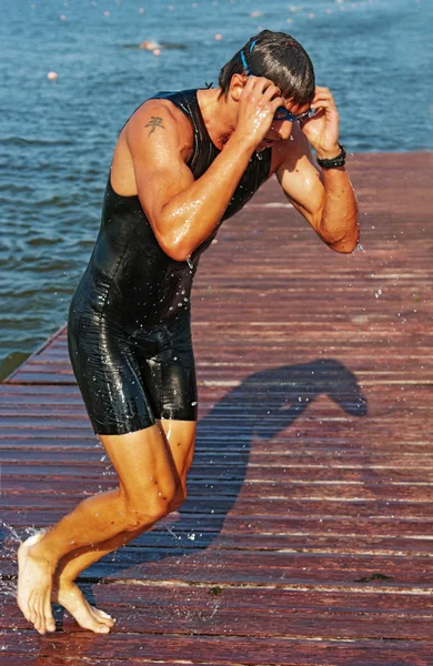 Молодой спортсмен бежит от воды на понтоне — стоковое фото