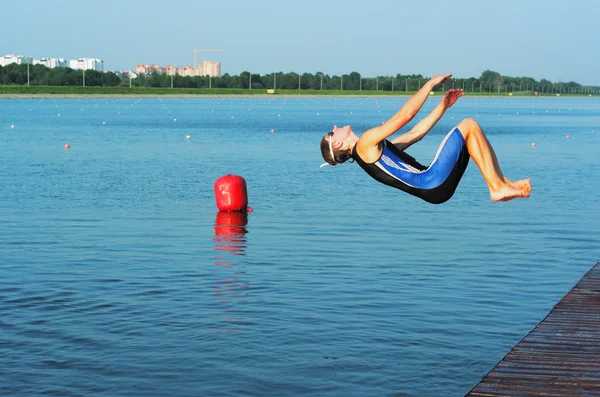 The young sportsman jump in water — Stock Photo, Image