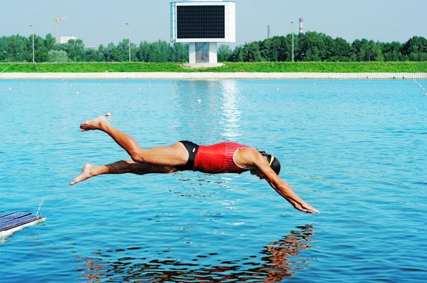 那位运动员潜入蓝色的水里 免版税图库照片