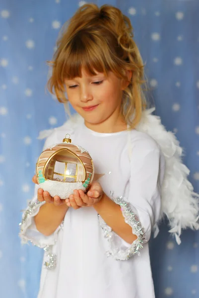 Engel meisje Kerstmis bal in de hand houden — Stockfoto