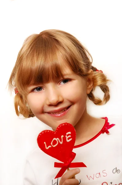Little girl with heart shape lolly — Stock Photo, Image
