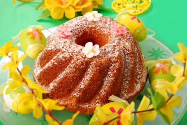 Traditional ring cake with icing sugar on easter table clipart