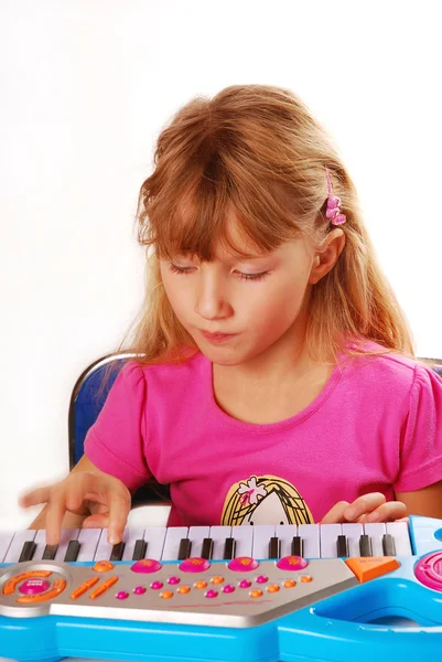 小さな女の子がピアノの鍵盤を遊んで — ストック写真