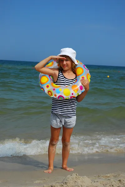 年轻的女孩站在带充气环海滨 — 图库照片