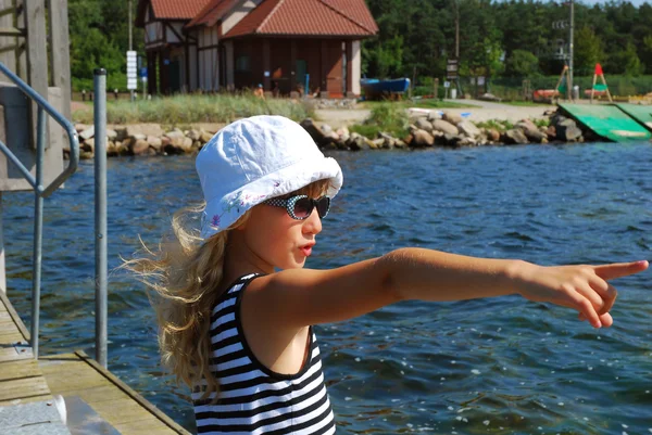水の上の彼女の指を指している休日に若い女の子 — ストック写真