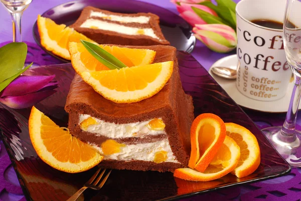 Chocolate cake with cream and oranges — Stock Photo, Image