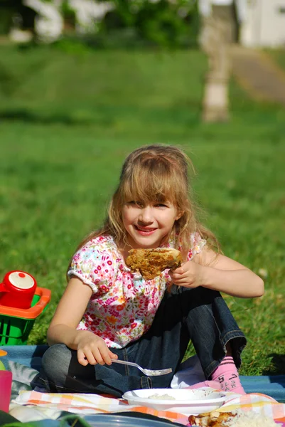 Ung jente som spiser på piknik – stockfoto