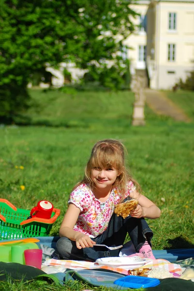 Chica joven comiendo en el picnic — Foto de Stock