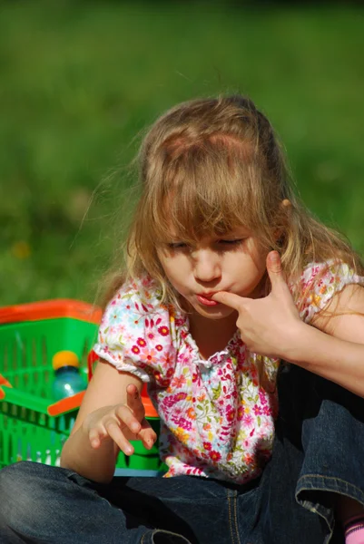 Молодая девушка ест на пикнике — стоковое фото