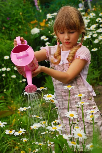 Молодая девушка в саду с лейкой банкой — стоковое фото