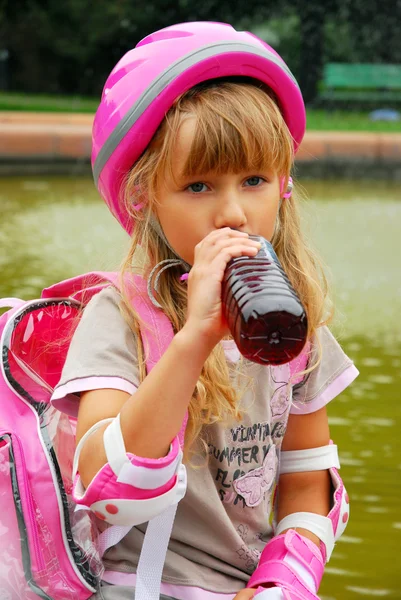 Young girl drinking and rollerskating — Stock Photo, Image