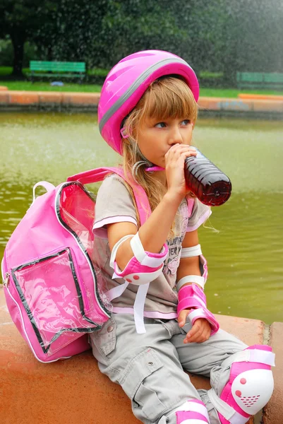 Chica joven bebiendo y patinando — Foto de Stock
