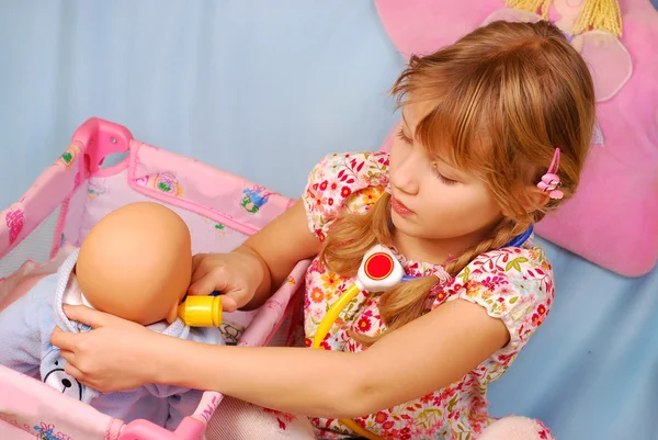 Liten flicka spelar med baby doll — Stockfoto