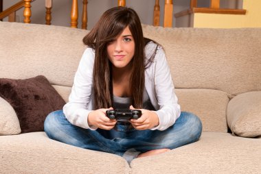 genç kadın evde kanepede iskambil video oyunları konsantre