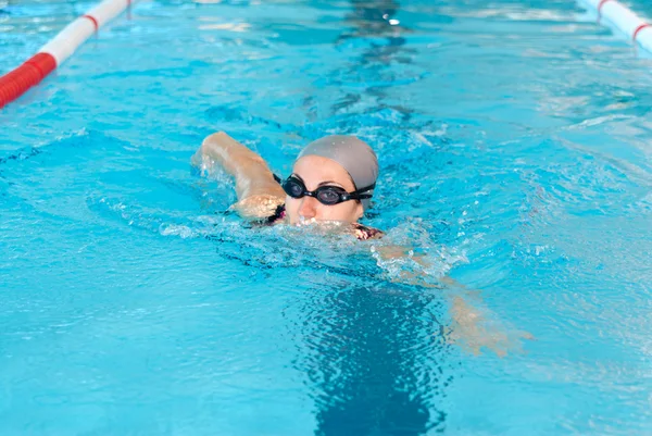 Giovane donna nuotare sulla piscina coperta. stile breastroke . — Foto Stock