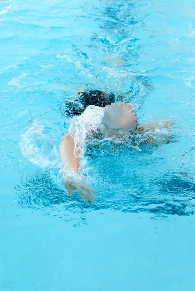 Giovane donna nuotare sulla piscina coperta. modalità stile libero . — Foto Stock